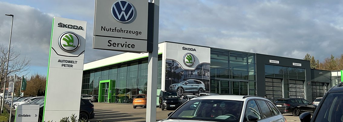 Aussenansicht des Autowelt Peter Autohauses in Nordhausen. Im Vordergrund ein Schild mit Volkswagen-Logo.