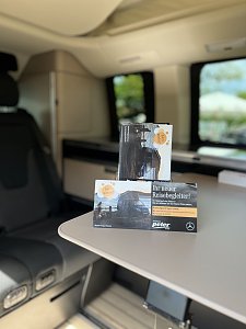 Innenraum Camper-Van: Prospekte auf einem Tisch im Innenraum eines Mercedes-Benz Camper-Vans.