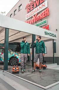 �koda Roadshow B&uuml;hne mit einem bunt beklebten Fahrzeug; davor 2 Skoda Moderatoren mit Mikros.



